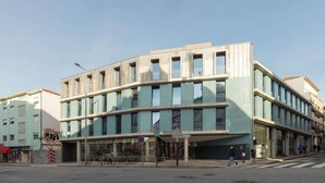 Ein mehrgeschossiges Gebäude mit modernem architektonischen Design, ausgestattet mit großen Fenstern und einem Flachdach.