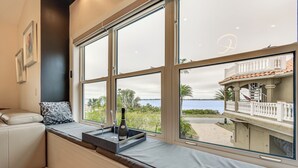 Una habitación con un amplio asiento junto a la ventana, una botella de champán y copas sobre una bandeja.