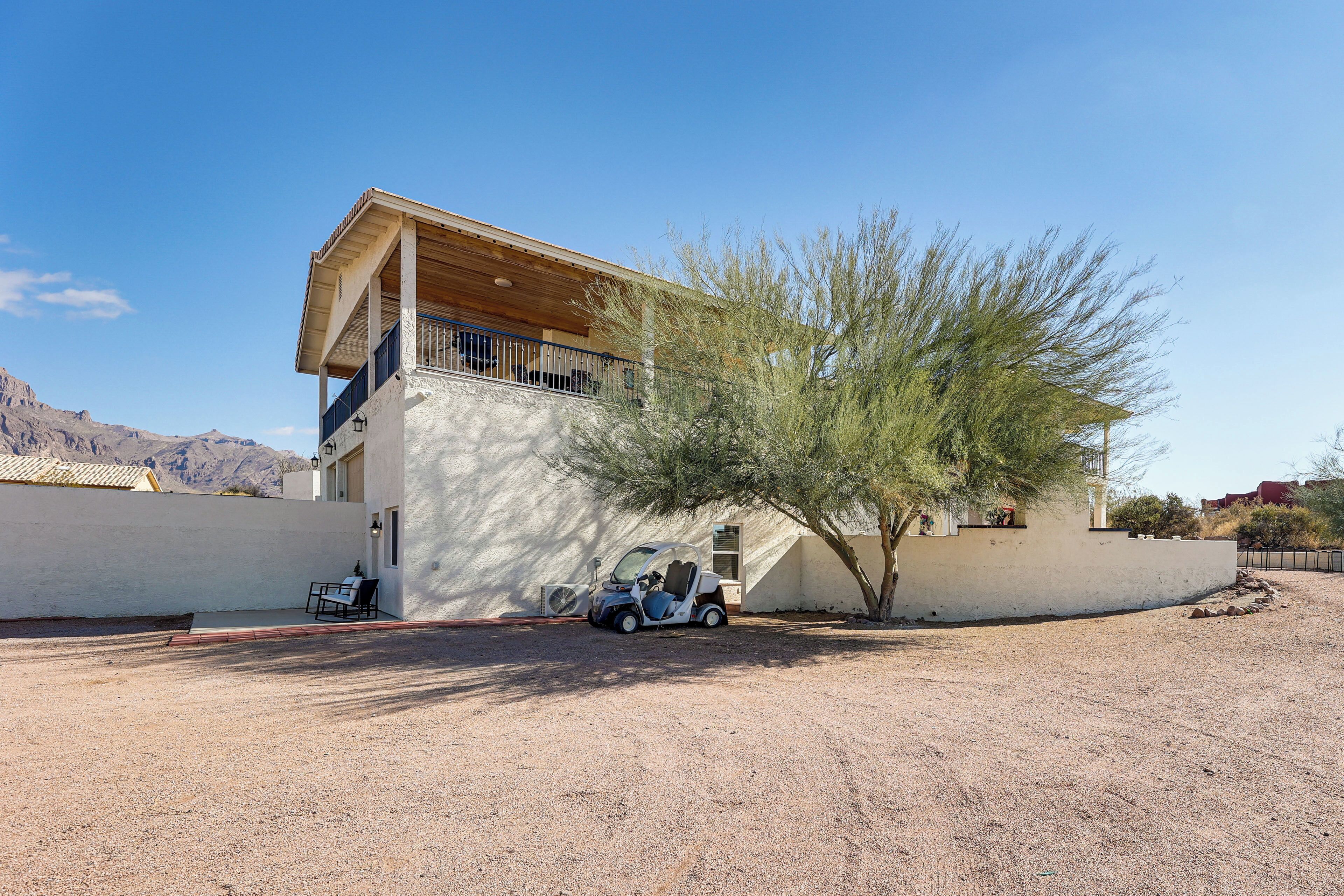 A two-story building with a balcony, a covered outdoor seating area, and a parked golf cart.