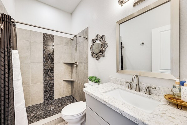 A modern bathroom with a shower, toilet, sink, and a large mirror. - Cozy Couple's Retreat w/ Views in Apache Junction (Apache Junction)