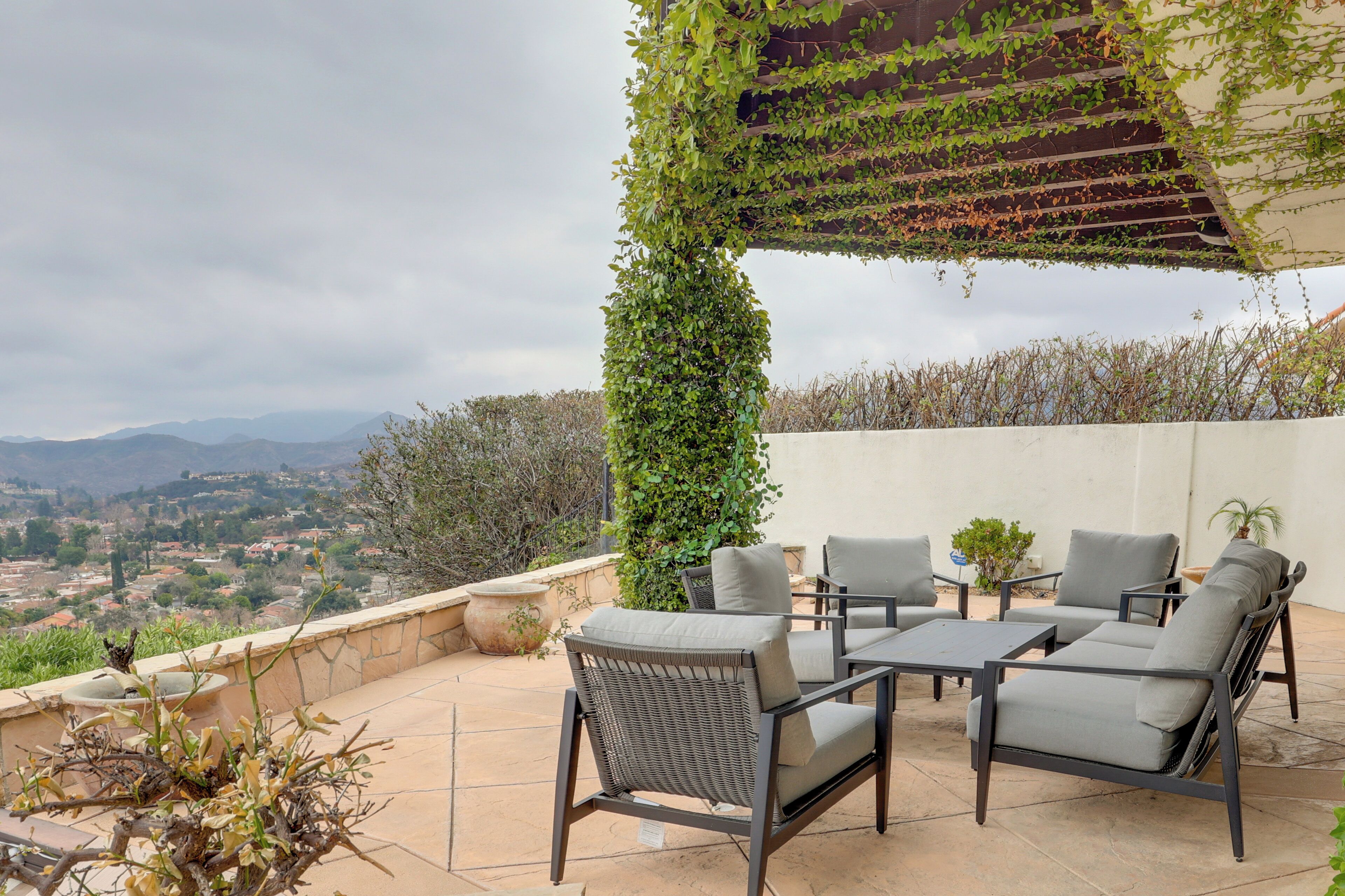 An outdoor patio with wicker furniture and a view of the countryside.