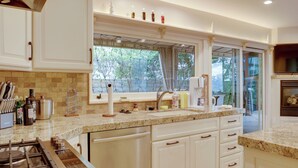 A modern kitchen with white cabinetry, a granite countertop, and a large window providing a view of the outdoors. - 2 Mi to Promenade at Westlake: Mtn-view Haven! (Westlake Village)
