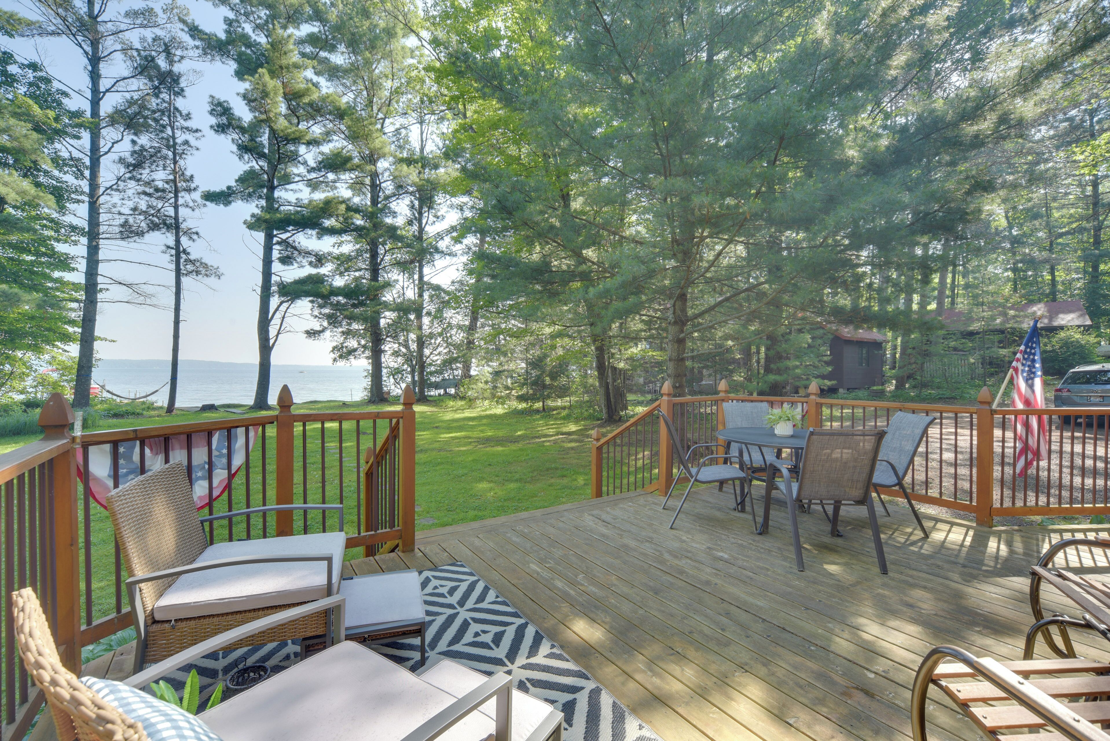 A wooden deck with outdoor furniture, a small table, and chairs.