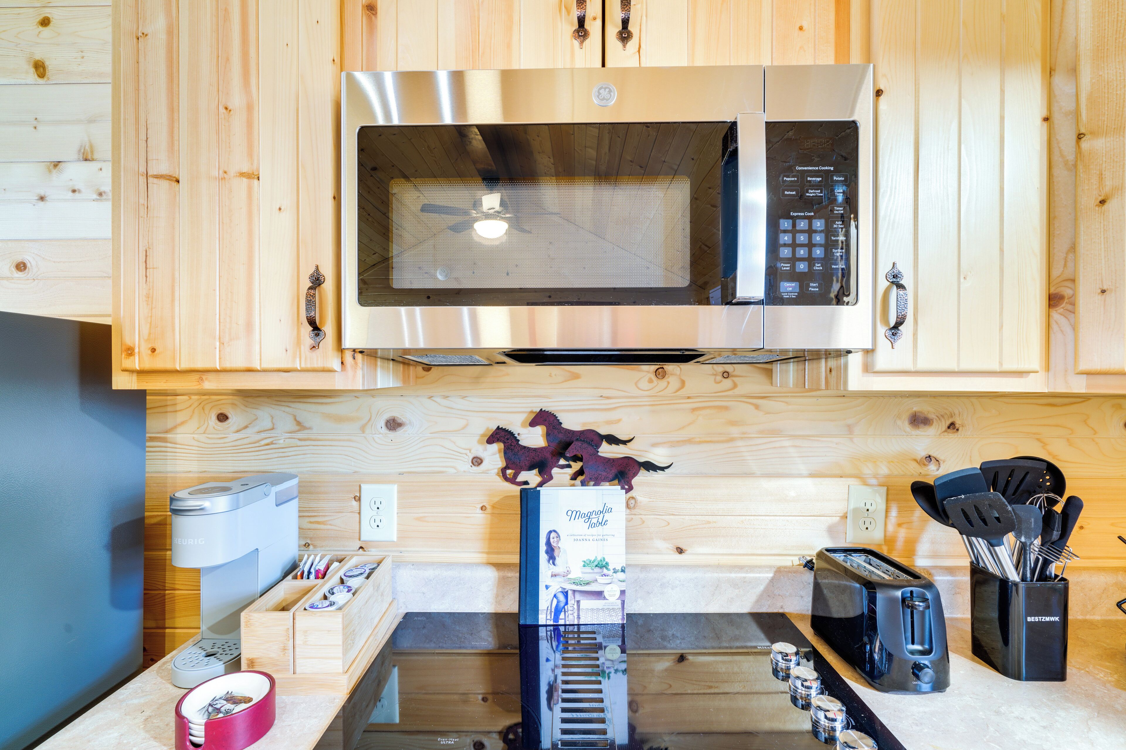 A kitchen with wooden cabinets, a microwave, a toaster, and a coffee machine.