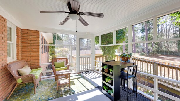 A covered patio with wicker furniture, a ceiling fan, and a view of a wooded area. - < 2 Mi to Ecu: Cozy Greenville Getaway w/ Porch! (Greenville)