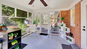 A sunlit porch with a ceiling fan, white railings, and a brick wall. - < 2 Mi to Ecu: Cozy Greenville Getaway w/ Porch! (Greenville)