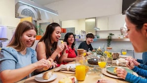 A group of people dining at a table with various foods and drinks. - Porto Lounge Hostel - Cozy Bed in Mixed Dorm (Porto)