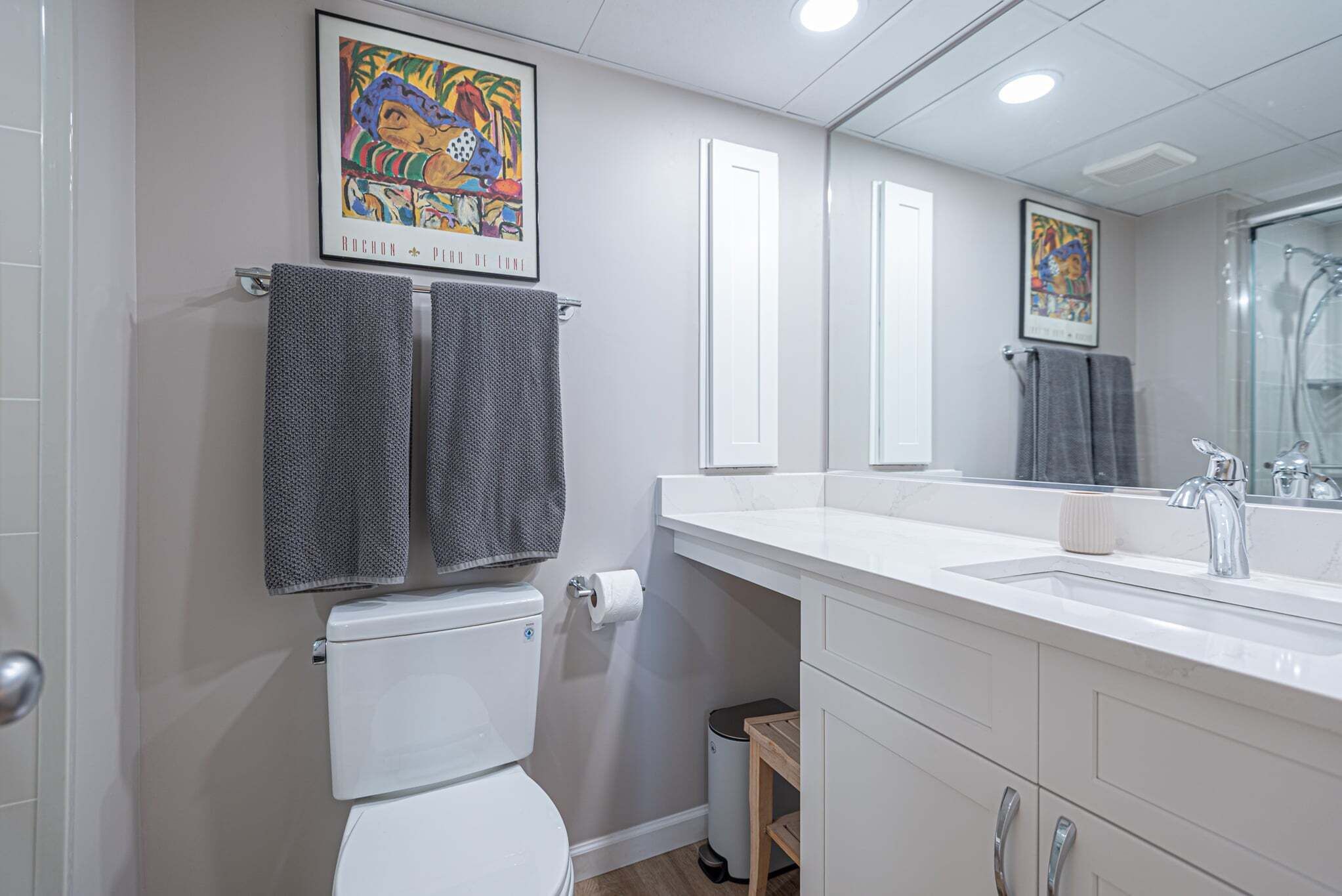 Ein modernes Badezimmer mit Toilette, Waschbecken und Spiegel.