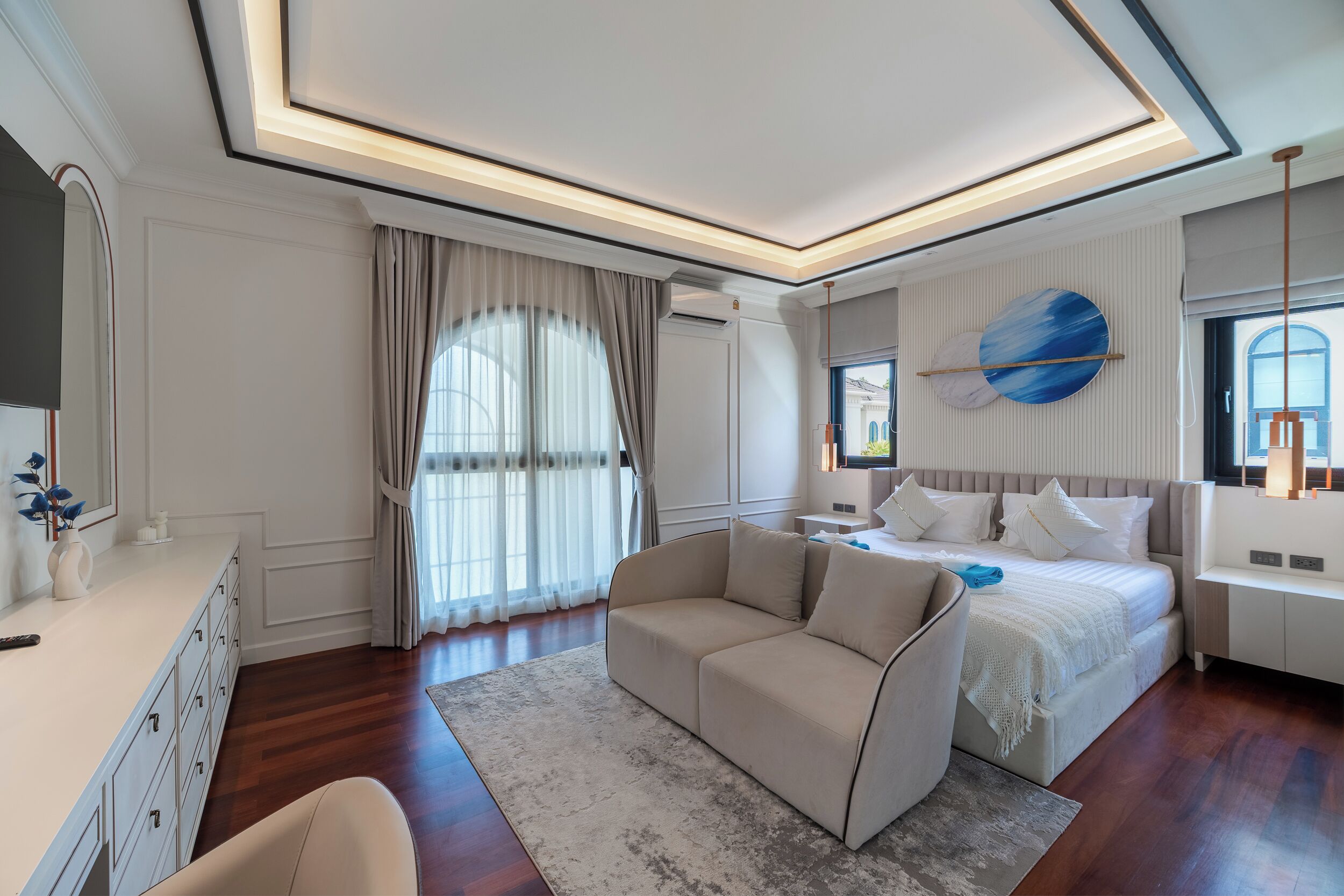 Une chambre moderne avec un grand lit, un canapé et une commode.