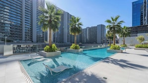 A rooftop pool area with multiple swimming pools, palm trees, and high-rise buildings in the background. - StayShort - 3 Bedroom Apartment in Sterling West with Full Burj Khalifa Views (Business Bay)