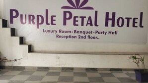 A sign for Purple Petal Hotel advertising luxury rooms, banquet, party hall, and reception on the 2nd floor. - PURPLE PETAL HOTEL (Rohtak)