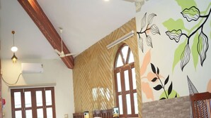 Ein Zimmer mit zwei Betten, einem Holzstuhl, einem Tisch und einem Kamin aus Ziegeln.
