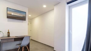 A modern office space with a desk, chair, and a mounted screen displaying 'hostwise'.