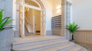 Eine Treppe mit Steinstufen führt zu einer Tür, einem Briefkasten und einem Blumentopf.