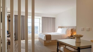 Ein Hotelzimmer mit Bett, Nachttisch und Blick auf die Stadt.
