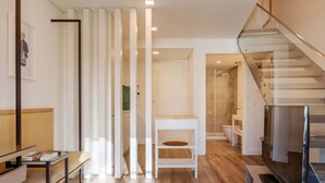 Un interior moderno con una escalera, un armario blanco y un televisor.