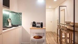 Une petite cuisine équipée d’une machine à café, d’un certificat encadré et d’une petite étagère.