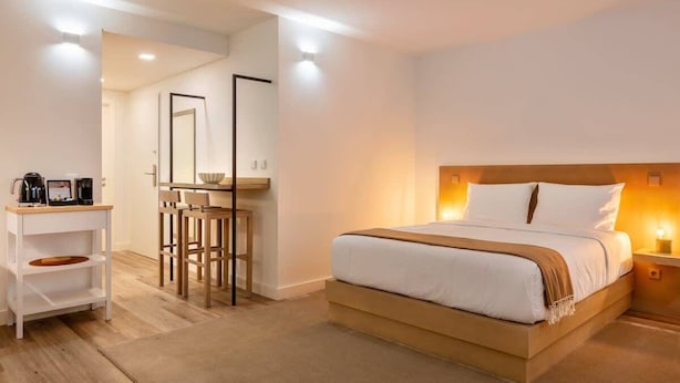 Une chambre à coucher comprenant un lit, une table de chevet et un bureau avec des chaises.