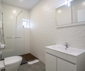 Un baño moderno con ducha, inodoro y lavabo.