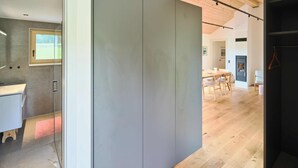 A modern interior with a wooden floor, a grey partition, and a white desk area with a window. - Chalet Hochsteiermark (Mariazell)