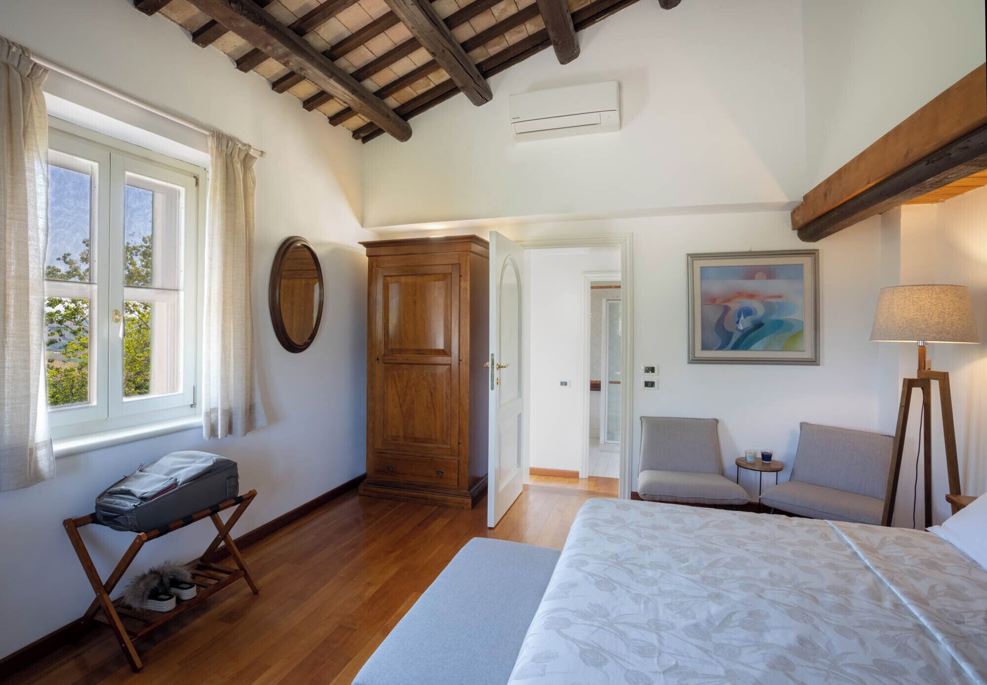 Un dormitorio con cama, escritorio, silla, lámpara y armario.