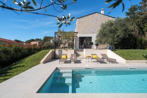 A modern house with a swimming pool, outdoor seating, and a stone facade. - Villa Casa Veritas with pool for 8 guests, quiet location, near Porec (Višnjan)
