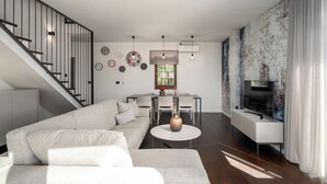 A modern living room with a sofa, dining table, and TV. - Villa Casa Veritas with pool for 8 guests, quiet location, near Porec (Višnjan)