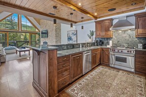A spacious kitchen with wooden cabinets, a built-in oven, and a large island with a sink. - Vail Mountain View #402 4 Bedroom Condo (Vail)
