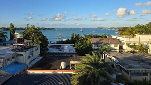 A coastal view with buildings, a clear sky, and boats on the water.