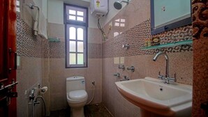 A bathroom with a toilet, a sink, a shower, and a window. - Bon Kiputhang (Chungthang)
