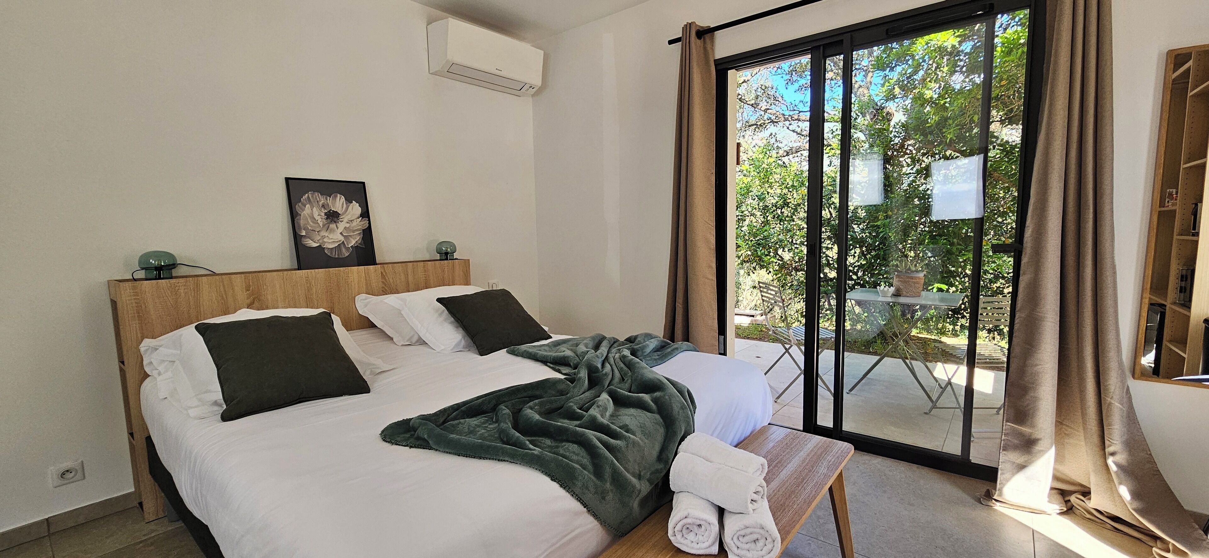 Habitación de hotel con dos camas, un ventanal grande y vistas al exterior.