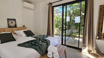 Habitación de hotel con dos camas, un ventanal grande y vistas al exterior.
