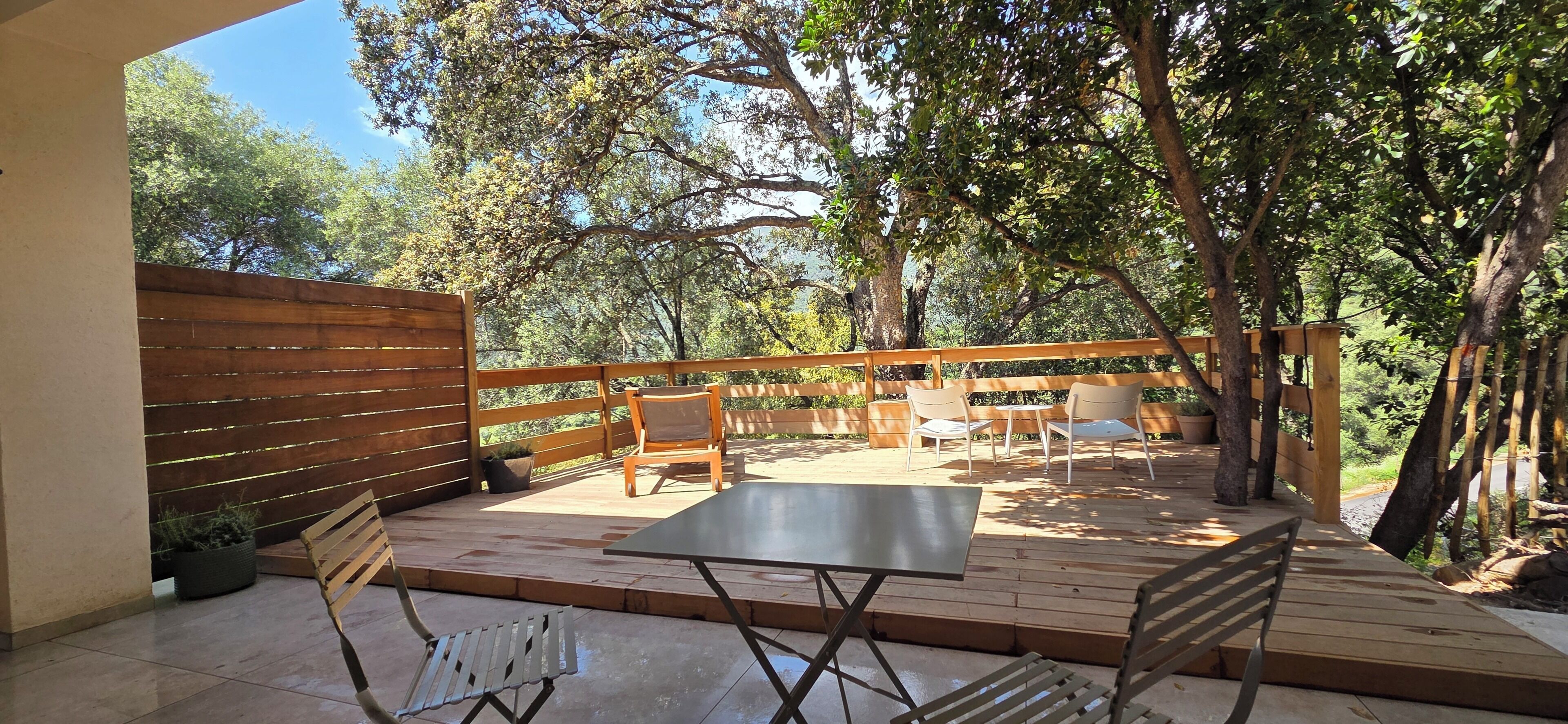 Un patio al aire libre con muebles de madera, una mesa y sillas.