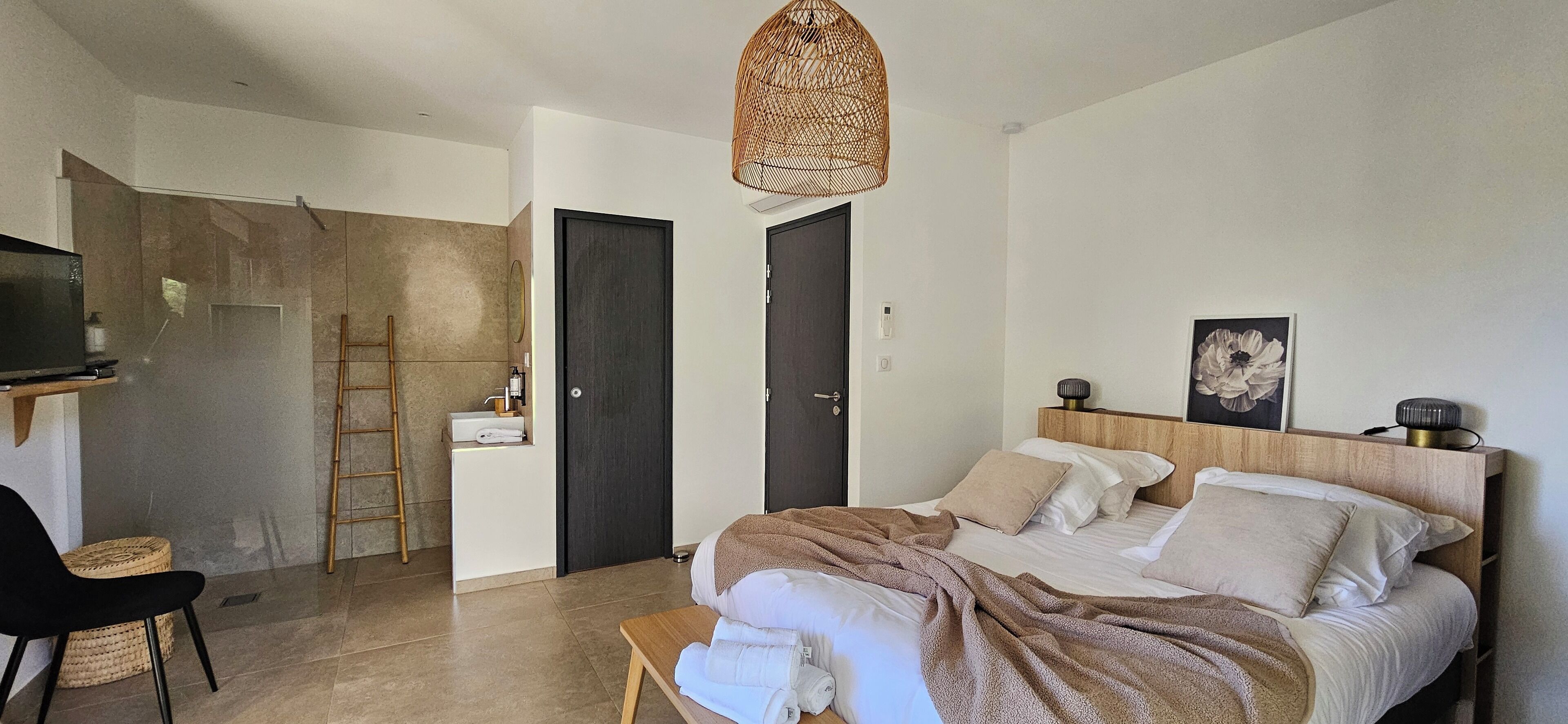 A modern bedroom with a bed, bedside table, and a television on a stand.