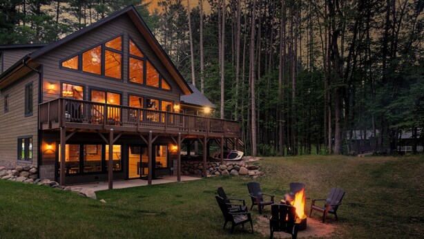 A log cabin with a large deck, outdoor seating, and a fire pit. - Make Memories In This Top Notch Lakefront Cabin (Stone Lake)