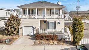 A two-story house with a front porch, a garage, and a small front yard.