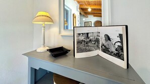 A room with a desk, a lamp, and a book with photographs. - "Le Corti Sarde Sea Breeze" (Bari Sardo)