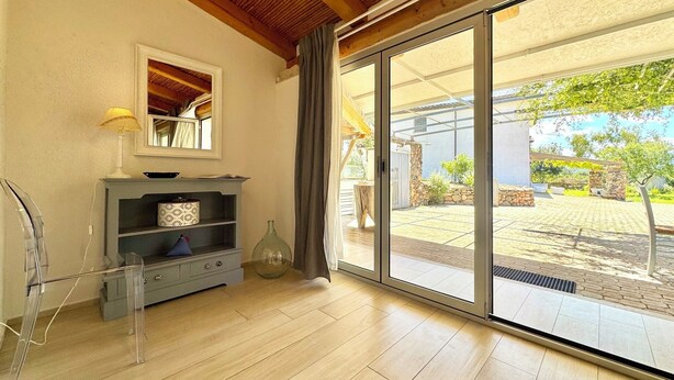 A modern living room with a large sliding glass door leading to an outdoor patio. - "Le Corti Sarde Sea Breeze" (Bari Sardo)