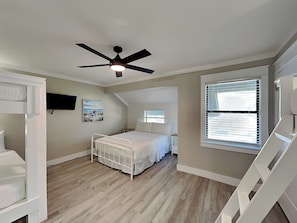 A bedroom with a bunk bed, a ceiling fan, a window with blinds, and a painting on the wall. - Easy on Eastern Lake | Pet Friendly Luxury Townhome (Santa Rosa Beach)