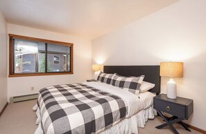 Relax in a stylish bedroom with a large bed and a window offering a view of the city.