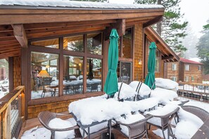Relax in a cozy cabin-style building with tables and chairs surrounded by breathtaking views of the surrounding landscape.
