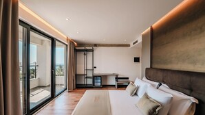 A modern hotel room with a large bed, a desk, and a sliding glass door to a balcony. - Cuni Luxury Hotel (Sarandë)