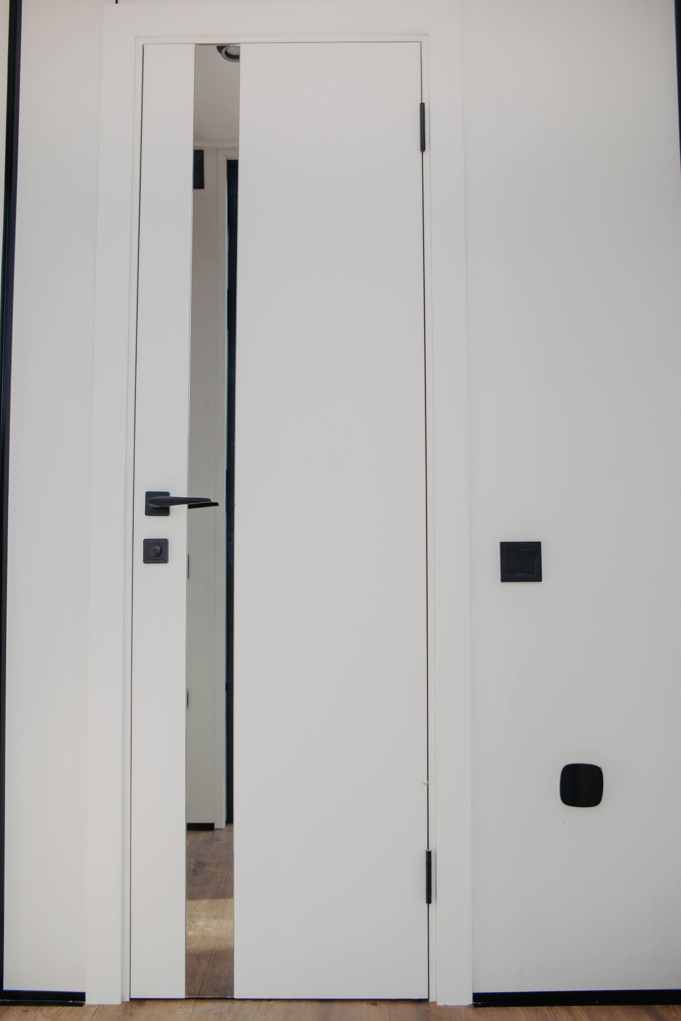 Una puerta blanca con manija y una placa cuadrada para el cerrojo.