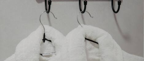 A white towel hanging on a black towel rack in a bathroom.