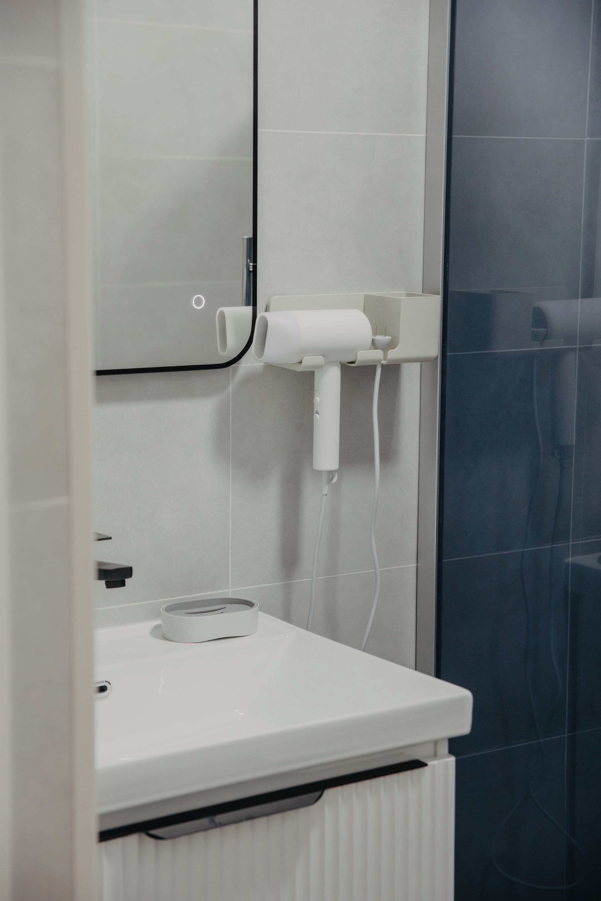 A bathroom with a white sink, a towel rack, and a mirror.