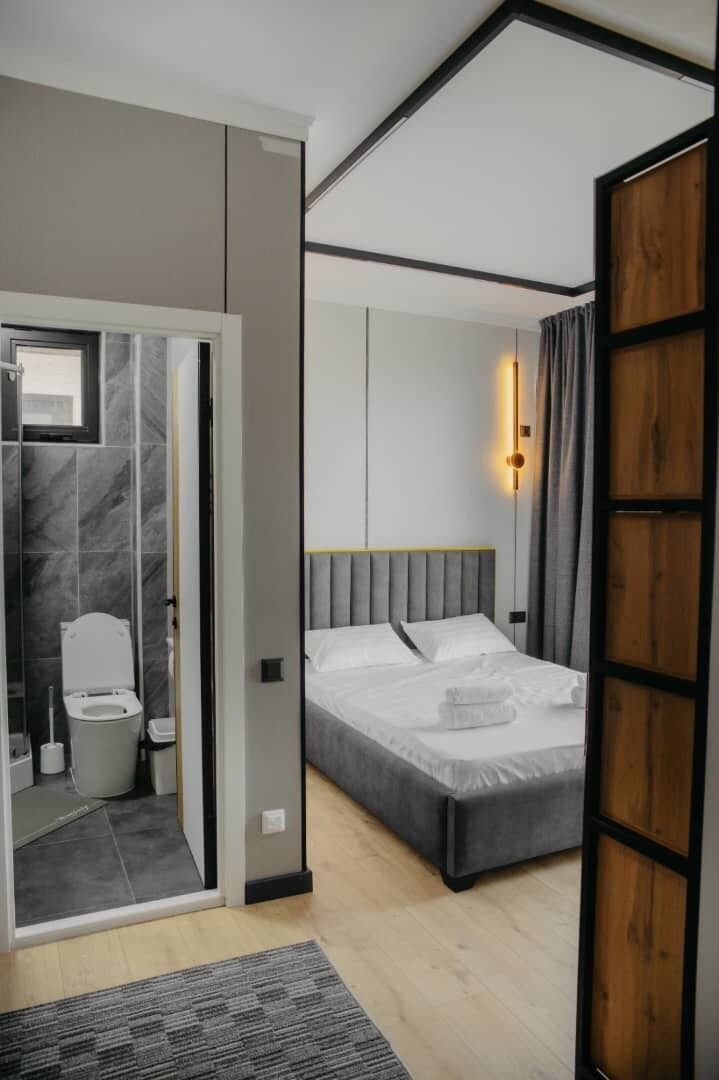 A modern bedroom with a bed, a bedside table, and a nightstand.
