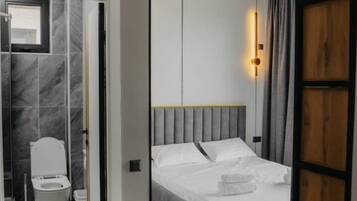A modern bedroom with a bed, a bedside table, and a nightstand.