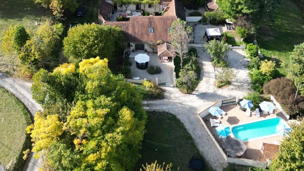 Une vue aérienne d’une grande maison avec une piscine, entourée d’arbres et d’un jardin.