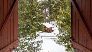 A wooden cabin with a snow-covered ground and surrounding trees. - Hotel Restaurant Camp del Serrat (Escaldes-Engordany)