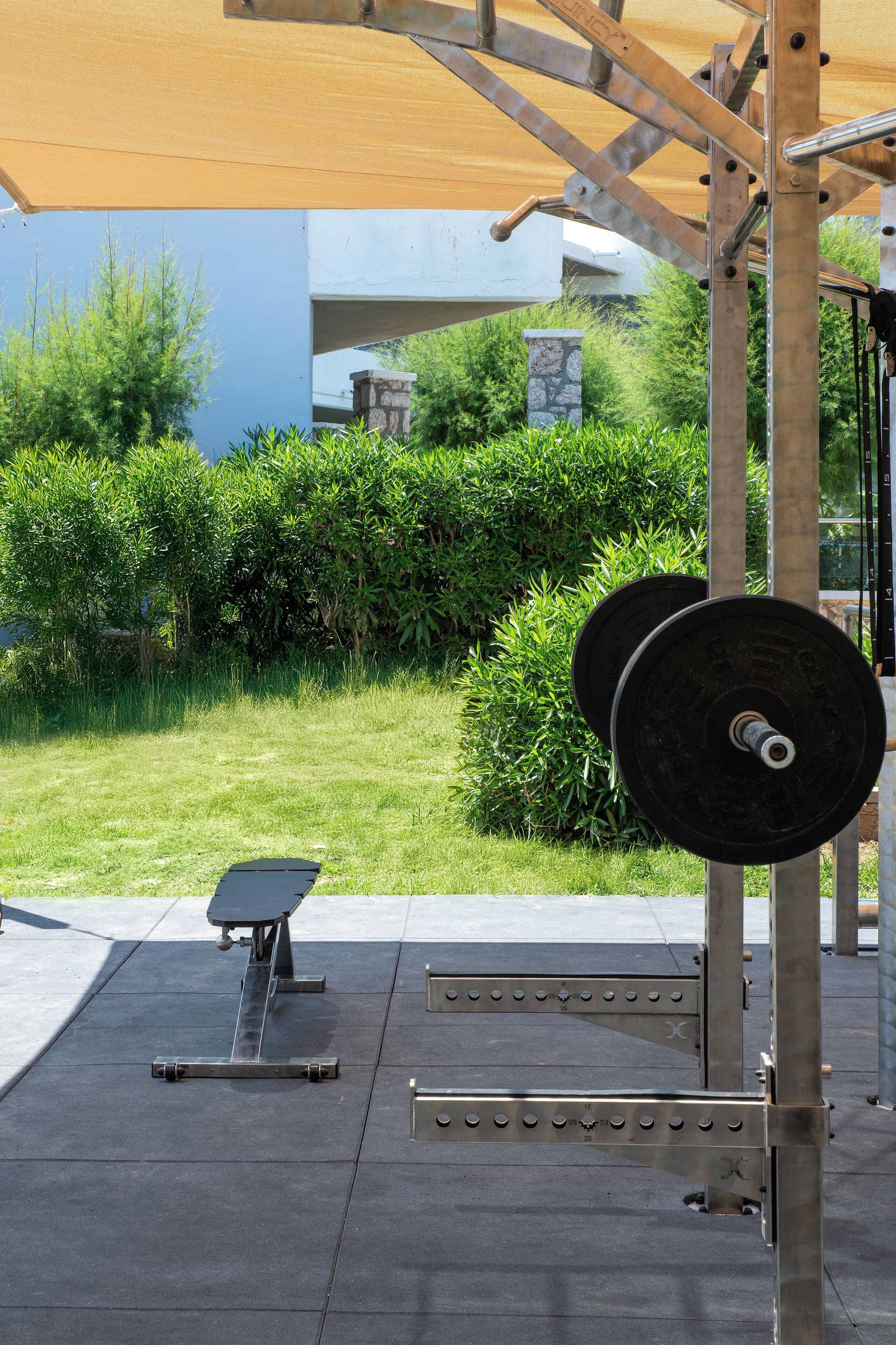 Un gimnasio al aire libre con una estación de levantamiento de pesas y un banco.